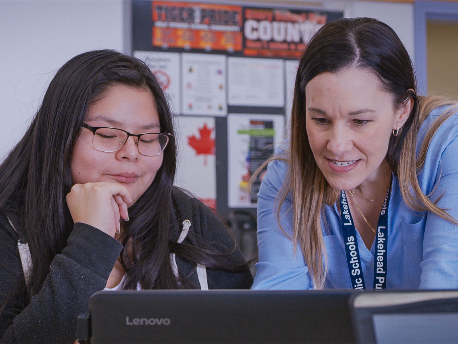 Teacher at computer with student